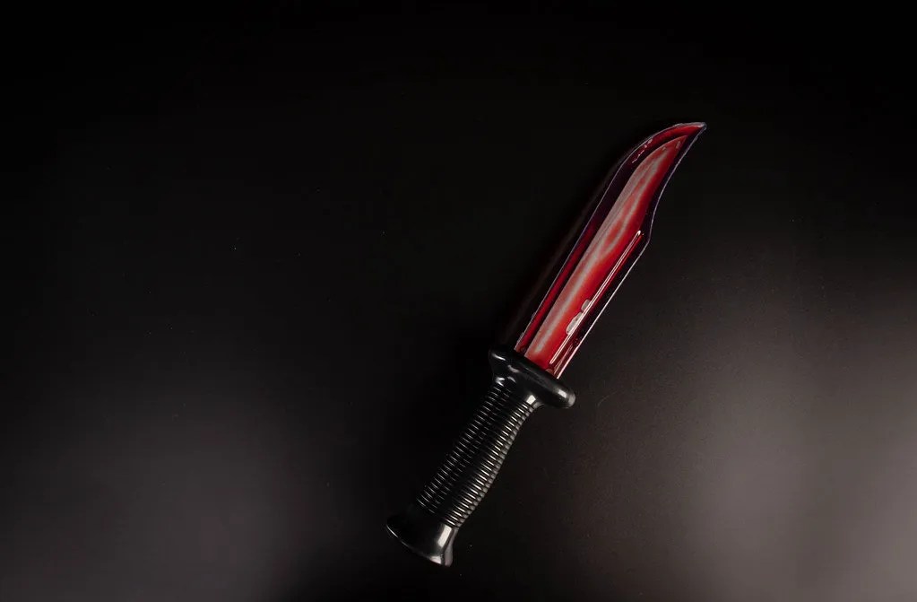 A picture of a bloody knife on a dark background.